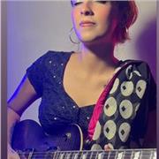 Female guitar tutor teaching guitar to students of all ages and expertise