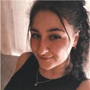 Chica amable acostumbrada a tratar con niños pequeños que ayuda con las tareas de niños de primaria